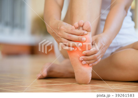 woman feeling pain in her foot at home.  39261583