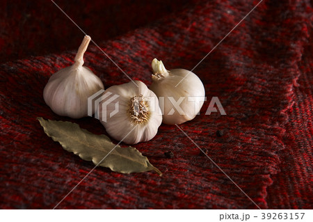 On the dark red textile, seasonings: garlic 39263157