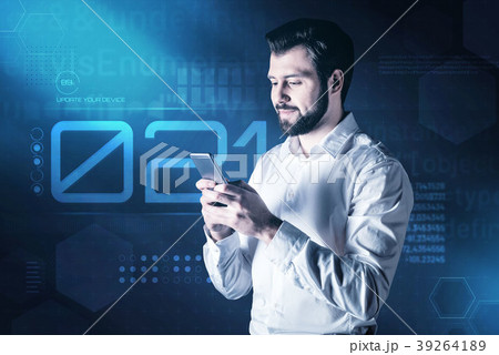 Smiling young man holding a smartphone and typing 39264189