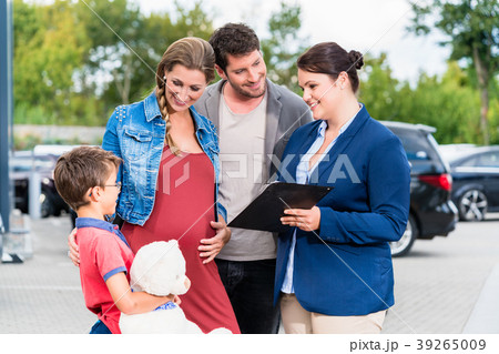Car dealer advising family on buying auto 39265009