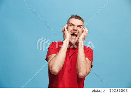 The young emotional angry man screaming on blue 39281008