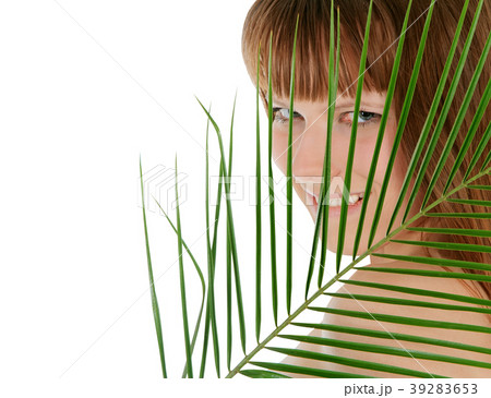 Pretty female behind palm leaf over white Pretty female behind palm leaf over white 39283653