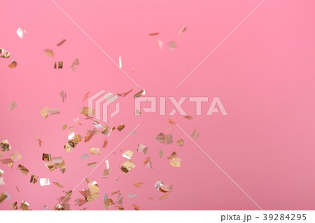 Golden confetti on pink background 39284295