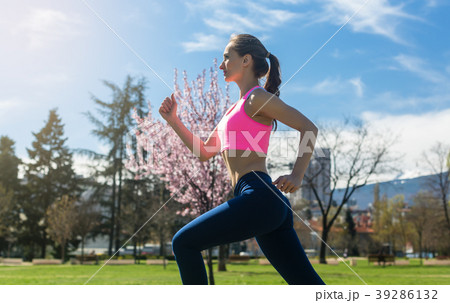 Woman running fast for sport on sunny day Woman running fast for sport on sunny day 39286132