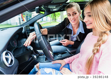 Student on wheel of car in driving lesson with her 39286148