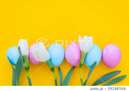 Easter eggs and spring flowers narcissi on yellow  39286568