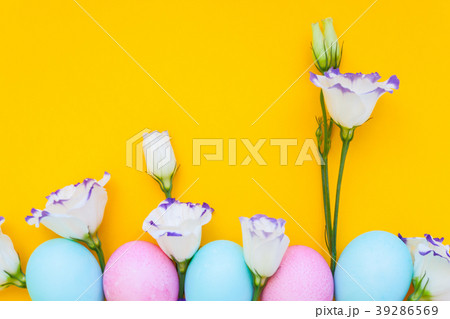 Easter eggs and spring flowers narcissi on yellow  39286569