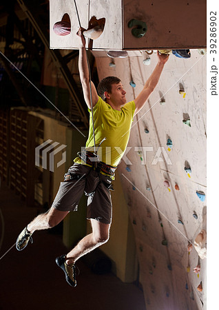 boy practicing rock-climbing on rock wall indoors boy practicing rock-climbing on rock wall indoors 39286902