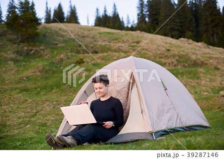 Young woman using laptop outdoors 39287146