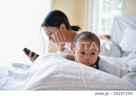 Newborn Concept. Mother and child on a white bed. Mom and baby b Newborn Concept. Mother and child on a white bed. Mom and baby b 39287200