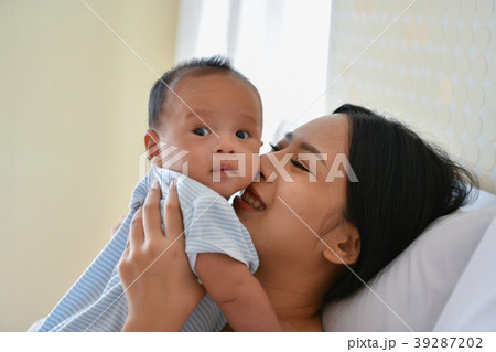 Newborn Concept. Mother and child on a white bed. Mom and baby b Newborn Concept. Mother and child on a white bed. Mom and baby b 39287202