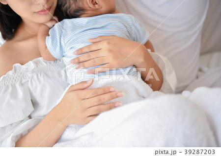 Newborn Concept. Mother and child on a white bed. Mom and baby b Newborn Concept. Mother and child on a white bed. Mom and baby b 39287203