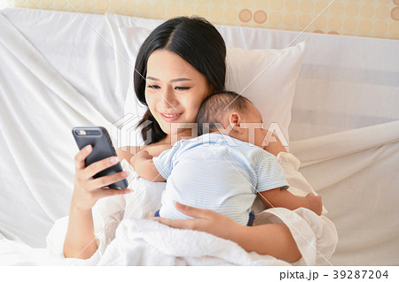 Newborn Concept. Mother and child on a white bed. Mom and baby b Newborn Concept. Mother and child on a white bed. Mom and baby b 39287204
