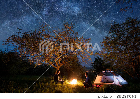 Tourists at campfire near tent. Night camping Tourists at campfire near tent. Night camping 39288061
