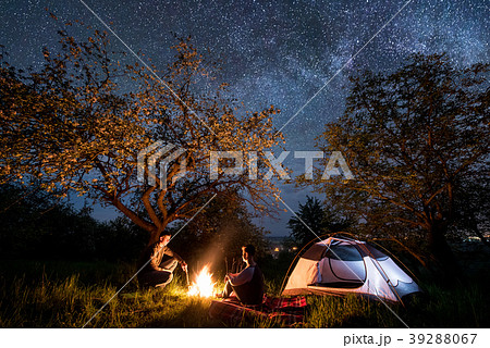 Tourists at campfire near tent. Night camping 39288067