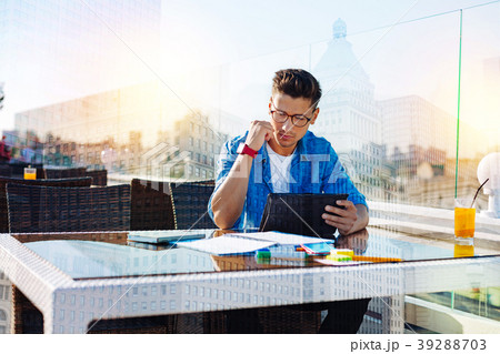 Concentrated man reading information on a tablet Concentrated man reading information on a tablet 39288703