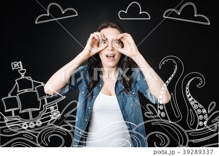 Emotional woman holding a binocular and looking at Emotional woman holding a binocular and looking at 39289337