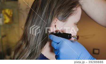 Adorable little girl having ear piercing process Adorable little girl having ear piercing process 39289886