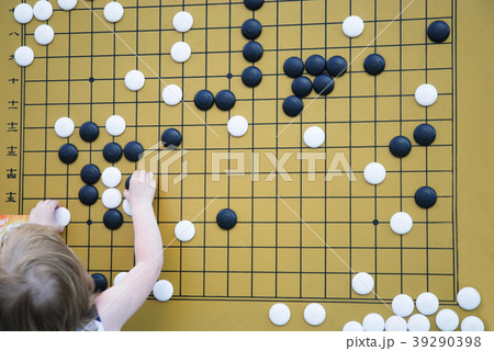 Little girl is playing on the board in checkers Go Little girl is playing on the board in checkers Go 39290398