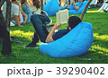 The guy is reading a book in the park  39290402