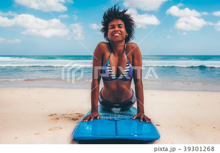 Surfer girl with afro hairstyle on the beach Surfer girl with afro hairstyle on the beach 39301268