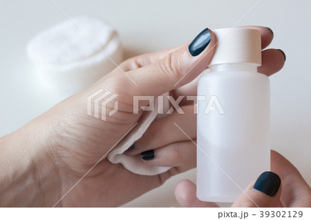 Woman is holding a nail polish remover Woman is holding a nail polish remover 39302129