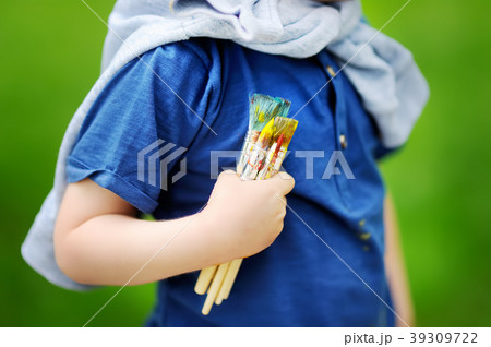 boy drawing with colorful paints in summer park boy drawing with colorful paints in summer park 39309722