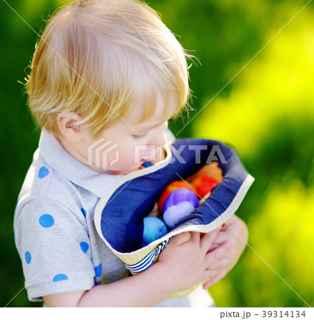 Little boy hunting for egg in spring garden on Easter day Little boy hunting for egg in spring garden on Easter day 39314134