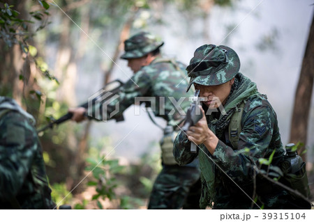 Squad of soldiers patrolling across the forest. 39315104
