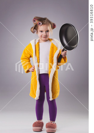 small hostess in a dressing gown with a frying pan 39316810