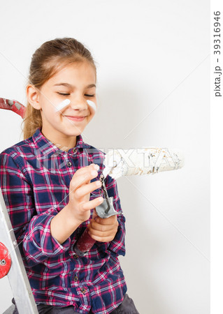 girl on building ladder using a brush for painting girl on building ladder using a brush for painting 39316946