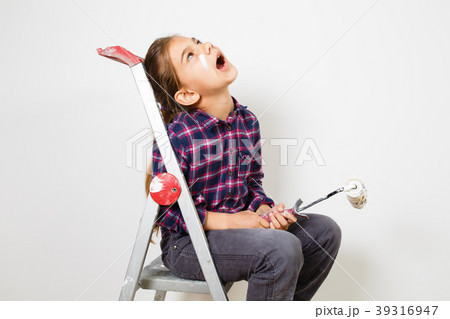 girl on building ladder using a brush for painting 39316947