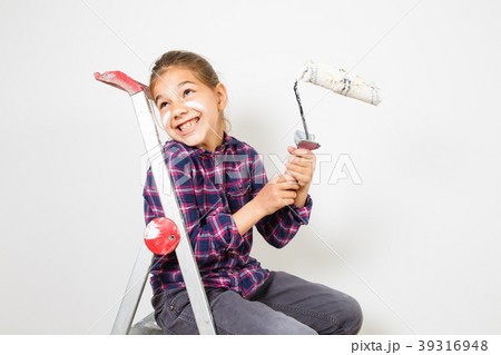 girl on building ladder using a brush for painting 39316948