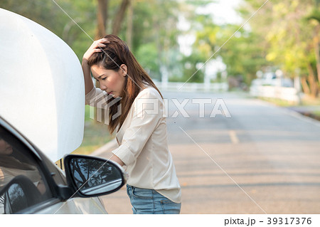 Young woman looking at her broken down car 39317376