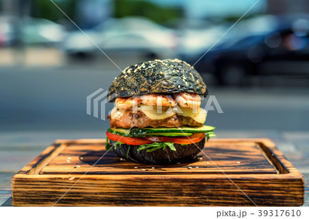 Black burger with prawns on wooden board 39317610