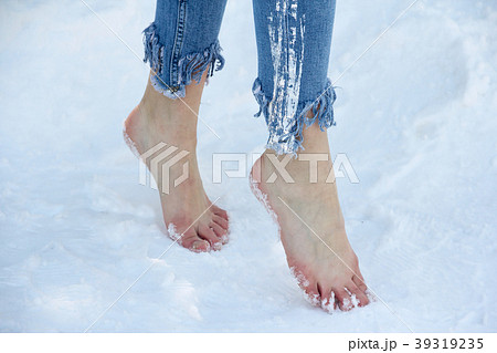 Slender beautiful girl feet close up in the snow. 39319235