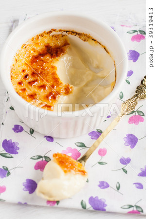 Ramekin with creme brulee and spoon in the middle Ramekin with creme brulee and spoon in the middle 39319413