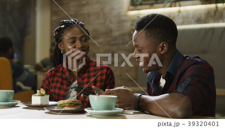 Relaxing black man and woman in cafe 39320401