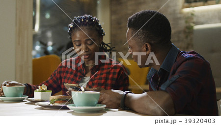 Relaxing black man and woman in cafe Relaxing black man and woman in cafe 39320403