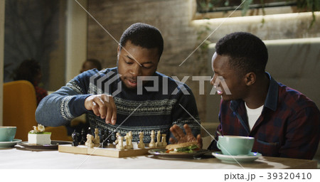 Content black men playing chess in cafeteria 39320410