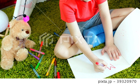 Little boy is writing MAMA in the drawing album in 39320970