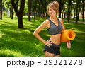 girl holding yoga mat in hands standing in park 39321278
