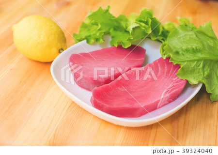 Two pieces of raw fresh tuna fillet on a plate Two pieces of raw fresh tuna fillet on a plate 39324040