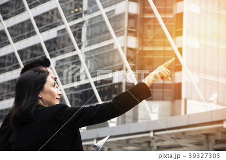 Smart business woman standing over modern building Smart business woman standing over modern building 39327305