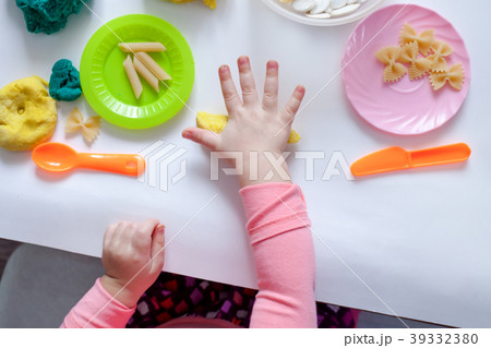 1.5 year old girl sits at a table and plays 1.5 year old girl sits at a table and plays 39332380