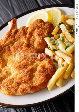 veal cutlet Milanese with lemon and French fries veal cutlet Milanese with lemon and French fries 39332504