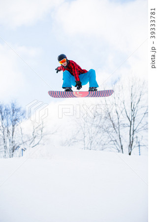 Picture of athlete with snowboard jumping in snowy 39333781