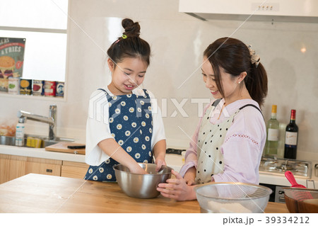 キッチンでお手伝いをする小学生の娘 39334212