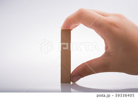 Hand holding wooden domino 39336405