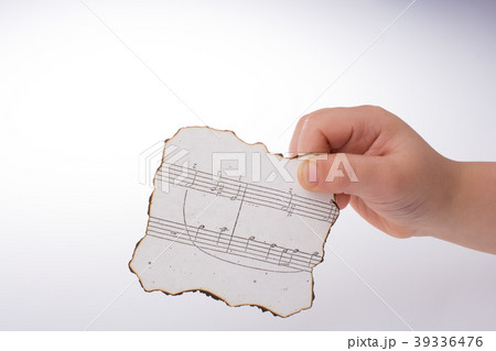 Musical notes on burnt paper in hand Musical notes on burnt paper in hand 39336476